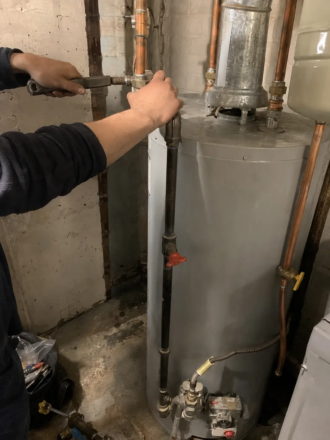Plumber connecting supply piping to a gas water heater
